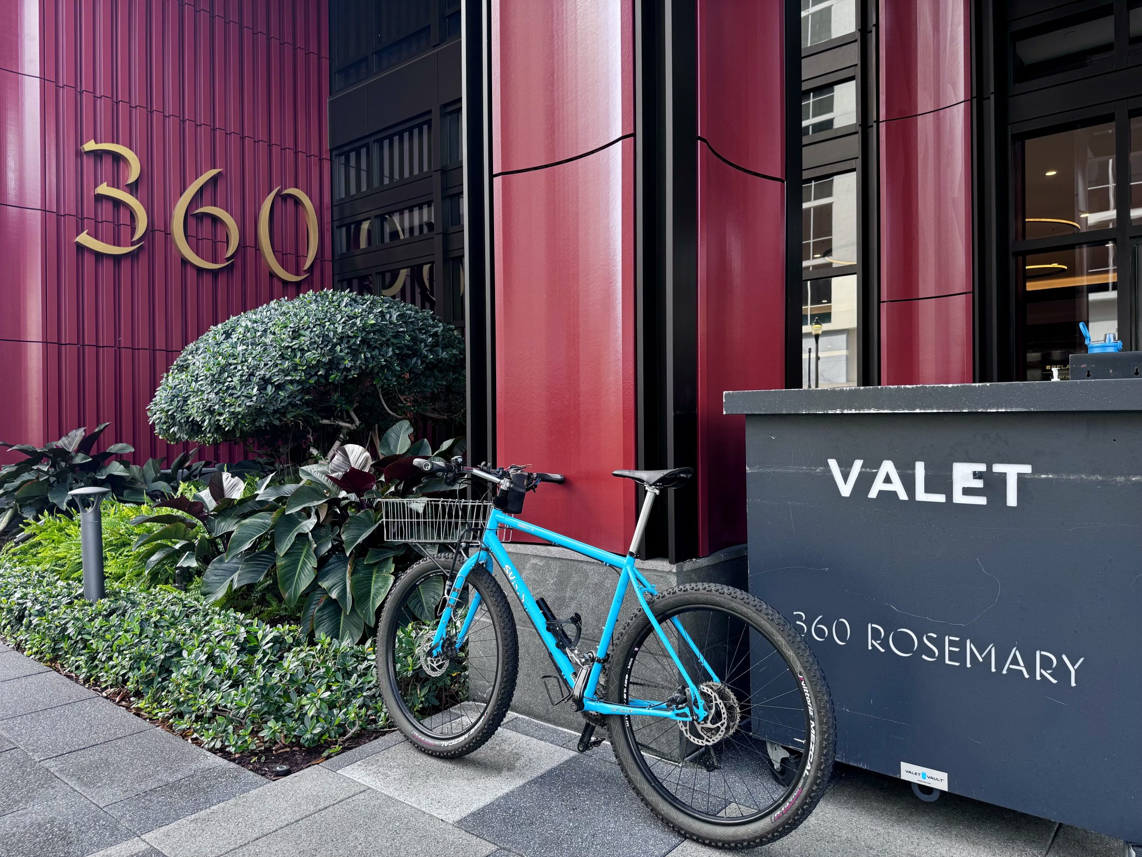 Bicycle leaning next to a valet stand.