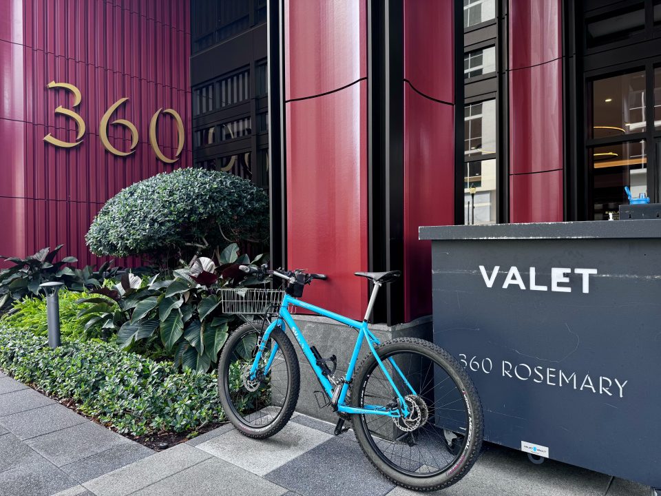 Bicycle leaning next to a valet stand.